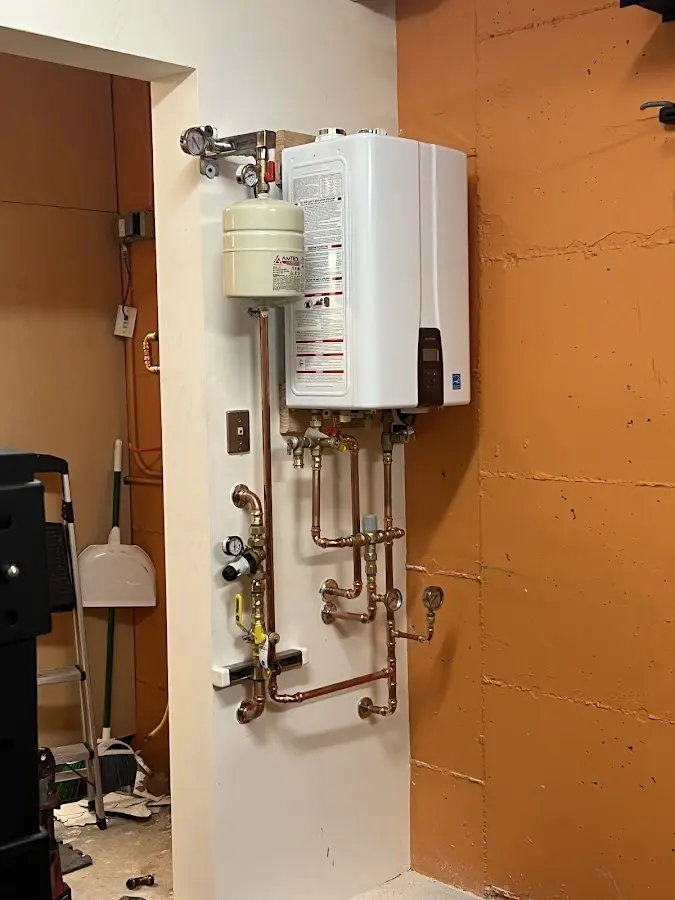 Plumbing technician inspecting water heater connections in Amberley